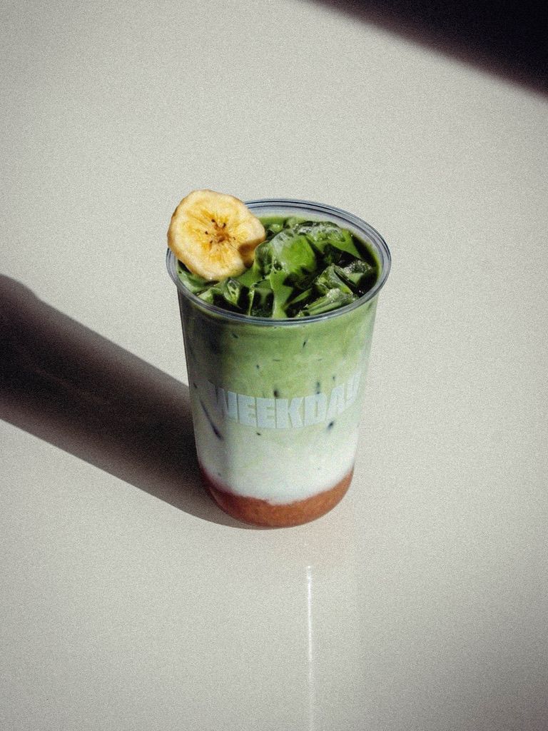 Iced Banana Bread matcha latte in a Weekday cup with a dried banana garnish